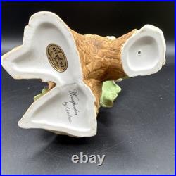 Porcelain bird figurine depicting a red-headed bird on branch with grape clusters